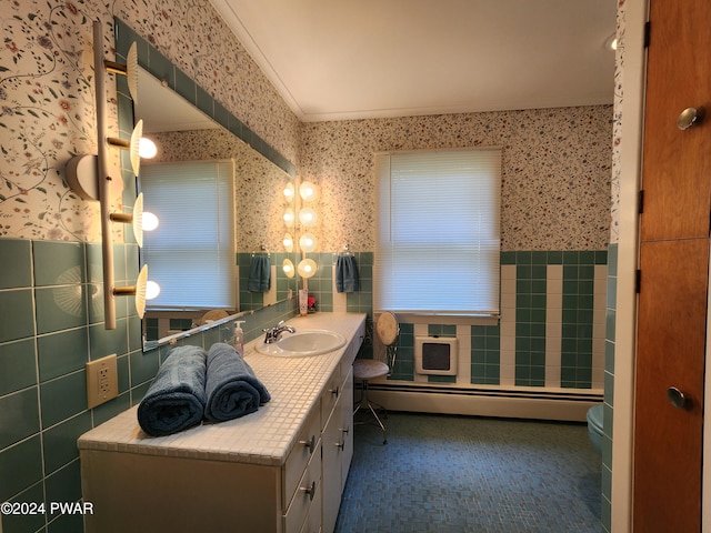 bathroom featuring vanity, toilet, tile walls, and a baseboard radiator