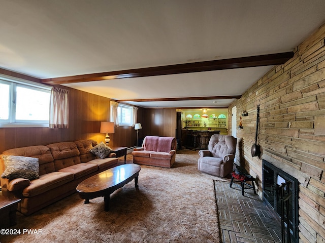 living room with beamed ceiling, wood walls, and a fireplace