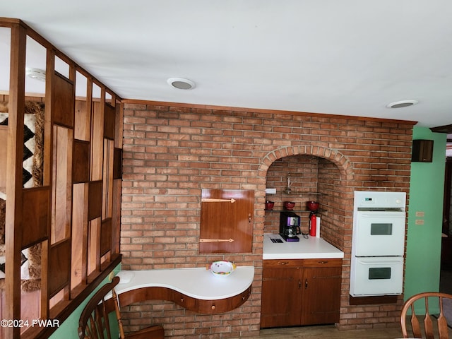 kitchen with double oven and brick wall