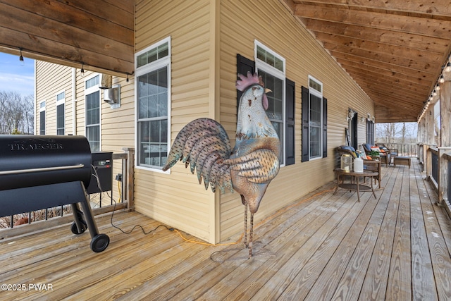 wooden deck with a grill and covered porch