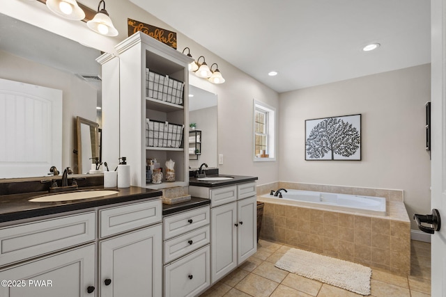 bathroom featuring vanity, tile patterned floors, and tiled bath