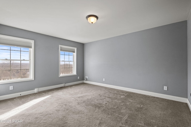 carpeted empty room with a baseboard radiator