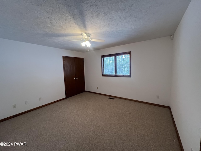 empty room with carpet, a textured ceiling, and ceiling fan