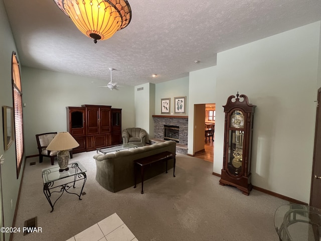 living room featuring a stone fireplace, ceiling fan, light carpet, and a textured ceiling