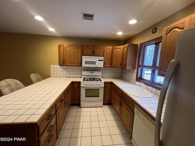 kitchen with white appliances, tile countertops, tasteful backsplash, and sink