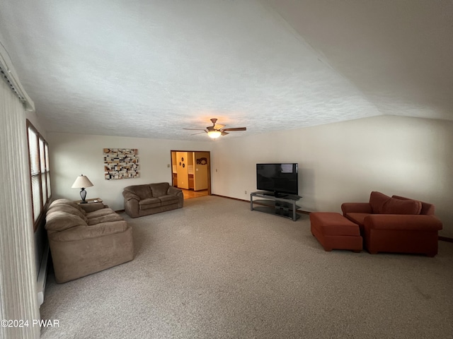 living room with ceiling fan, carpet floors, a textured ceiling, and vaulted ceiling