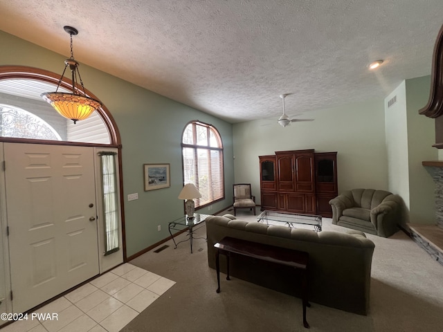 foyer featuring ceiling fan, light carpet, and a textured ceiling