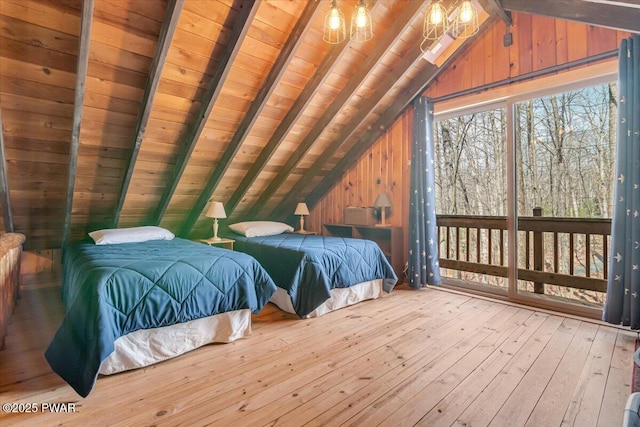 bedroom with lofted ceiling with beams, wood-type flooring, wood walls, and access to exterior