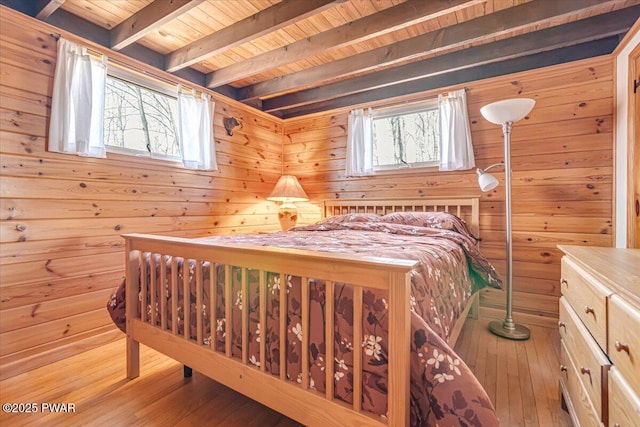 bedroom with wooden ceiling, wooden walls, wood-type flooring, and beam ceiling