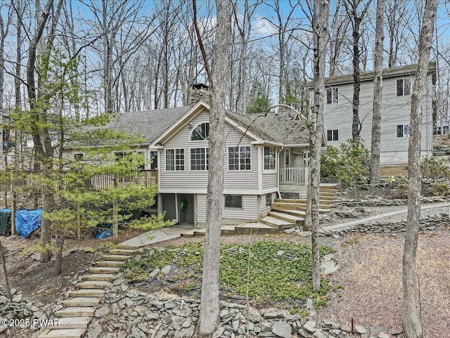 back of property featuring stairs and a chimney