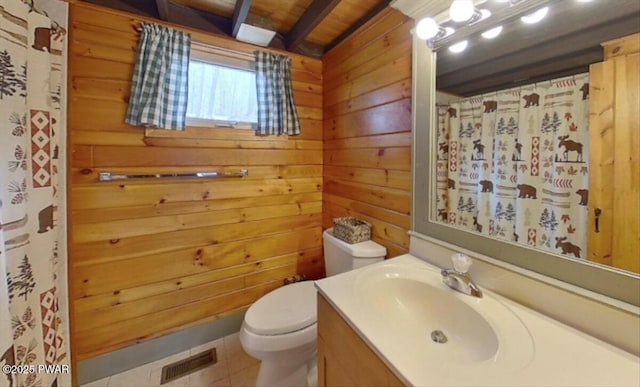 bathroom with visible vents, wood walls, toilet, tile patterned floors, and vanity