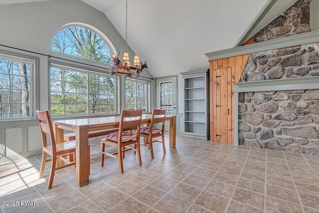 dining area featuring a notable chandelier and high vaulted ceiling