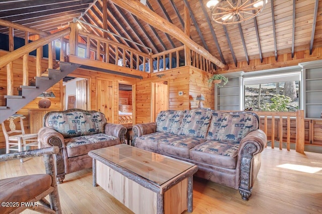 living area featuring wooden walls, beamed ceiling, wood ceiling, an inviting chandelier, and wood finished floors