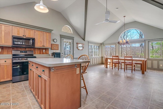 kitchen with a wealth of natural light, stainless steel range with electric stovetop, pendant lighting, and light countertops