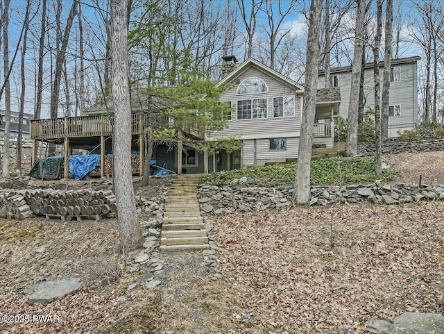 view of front of property with a chimney, stairs, and a deck