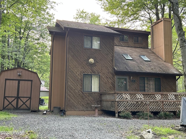 1024 Pitt Rd, Newfoundland, PA 18445 - back of house with a storage unit, a chimney, and a shingled roof