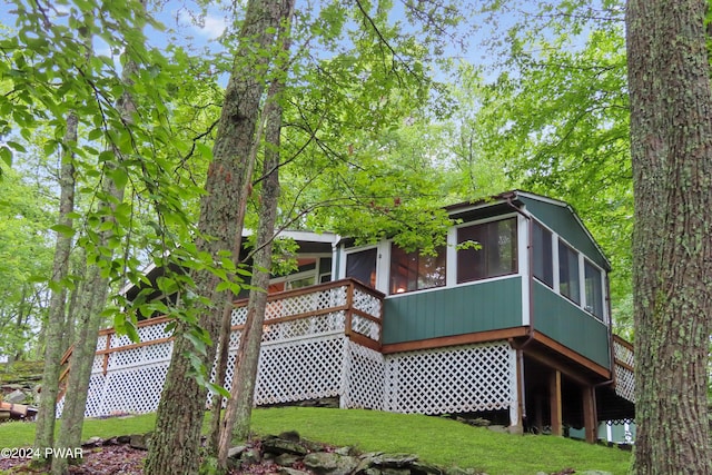 rear view of property with a sunroom and a lawn