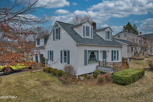 exterior space featuring a deck, a lawn, roof with shingles, and a chimney