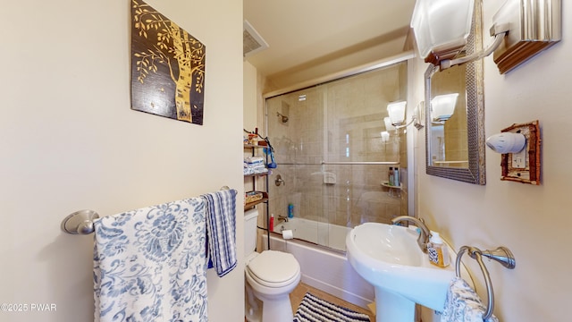 full bathroom with sink, combined bath / shower with glass door, and toilet