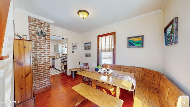 dining area with crown molding and hardwood / wood-style floors