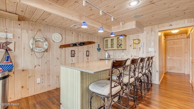 kitchen with wood ceiling, wood walls, wood finished floors, and visible vents