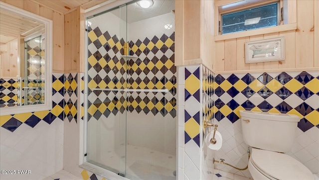 full bath featuring toilet, tile walls, and a shower stall
