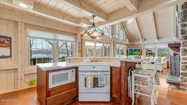 kitchen with brown cabinetry, wood finished floors, white appliances, open floor plan, and wood ceiling