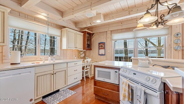 kitchen with beam ceiling, white appliances, light wood-type flooring, light countertops, and wooden ceiling