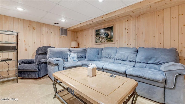 living room with visible vents, recessed lighting, and wooden walls