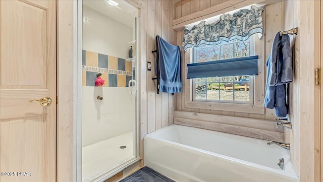 bathroom with a bath and a shower stall