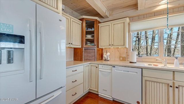 kitchen with a sink, white appliances, light countertops, wooden ceiling, and beamed ceiling