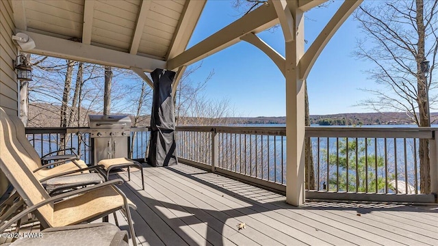 wooden terrace with a water view and grilling area