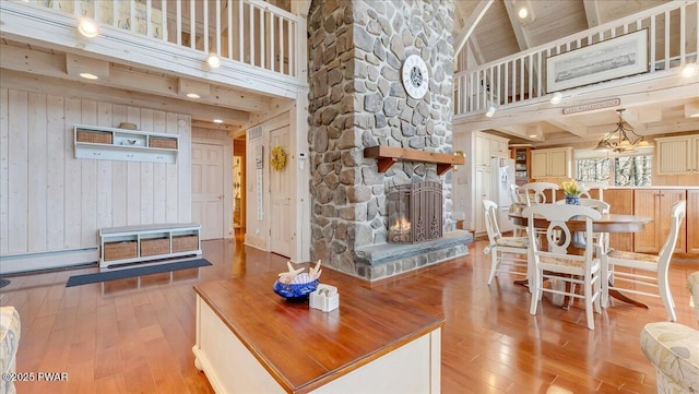 living room featuring high vaulted ceiling, a baseboard heating unit, and light wood finished floors