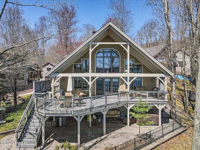 rear view of property featuring fence, stairway, and a deck