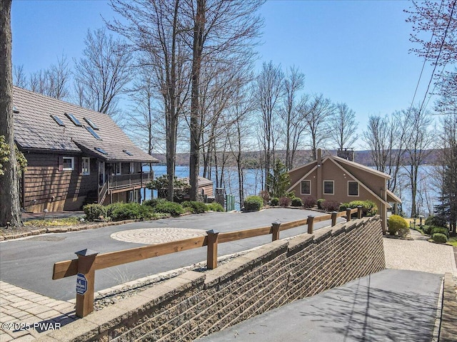 exterior space featuring a water view and a fenced front yard