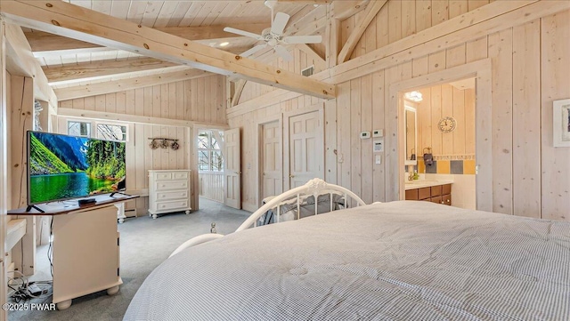 carpeted bedroom featuring wooden walls, high vaulted ceiling, beam ceiling, and connected bathroom