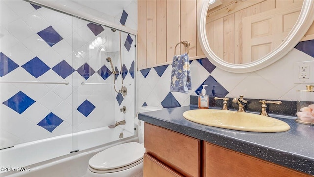 bathroom with vanity, shower / bath combination with glass door, backsplash, and toilet