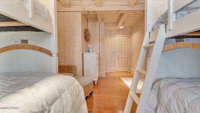 bedroom featuring wooden walls, wood finished floors, and a closet