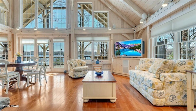 sunroom / solarium with a baseboard heating unit and beamed ceiling