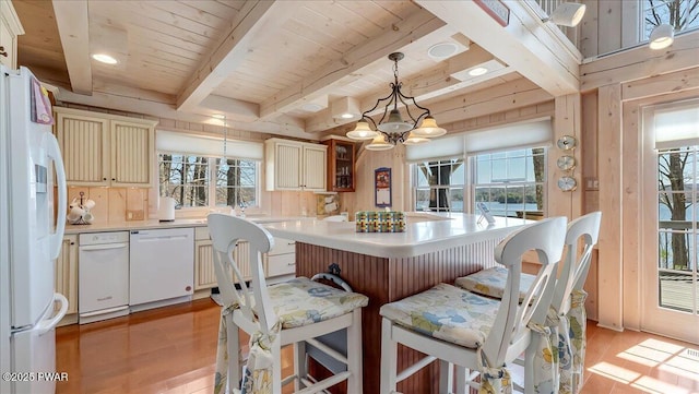 kitchen with light countertops, light wood finished floors, white appliances, and beam ceiling