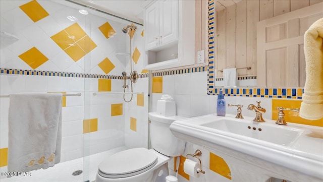 full bathroom featuring toilet, tile walls, a sink, and a stall shower