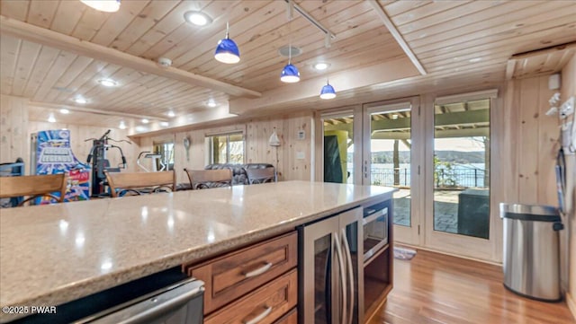 kitchen featuring light wood-style floors, wood ceiling, brown cabinets, and light stone countertops