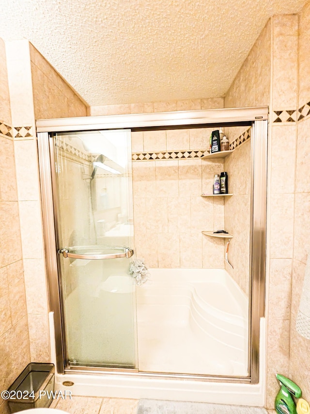 bathroom featuring a textured ceiling and an enclosed shower