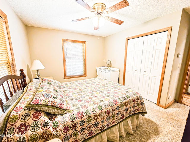 carpeted bedroom with ceiling fan, a textured ceiling, and a closet