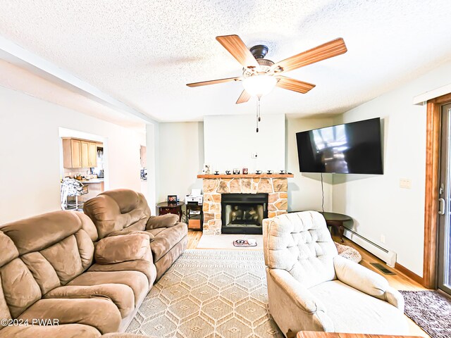 living room with hardwood / wood-style floors, ceiling fan, a textured ceiling, a fireplace, and baseboard heating