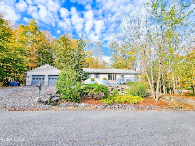 view of front of home featuring a garage and an outbuilding