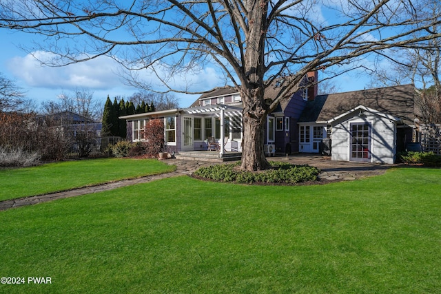 rear view of house with a pergola, a patio area, and a lawn