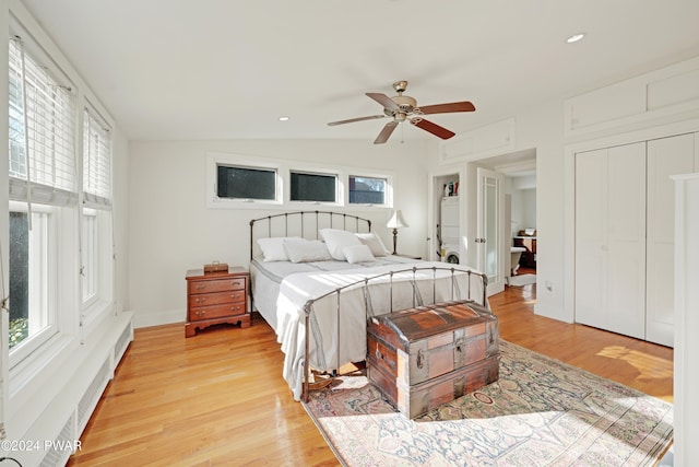 bedroom featuring light hardwood / wood-style floors, vaulted ceiling, and ceiling fan