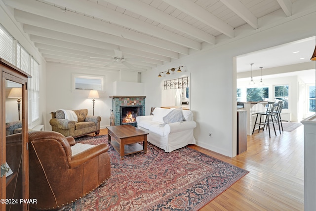 living room with beam ceiling, ceiling fan, and wood-type flooring