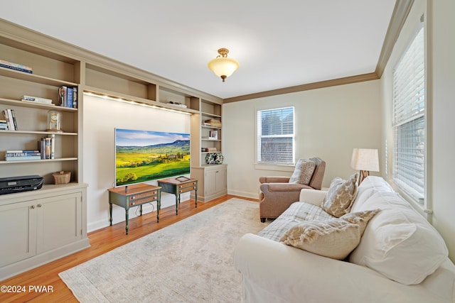 living room with crown molding, built in features, and light wood-type flooring